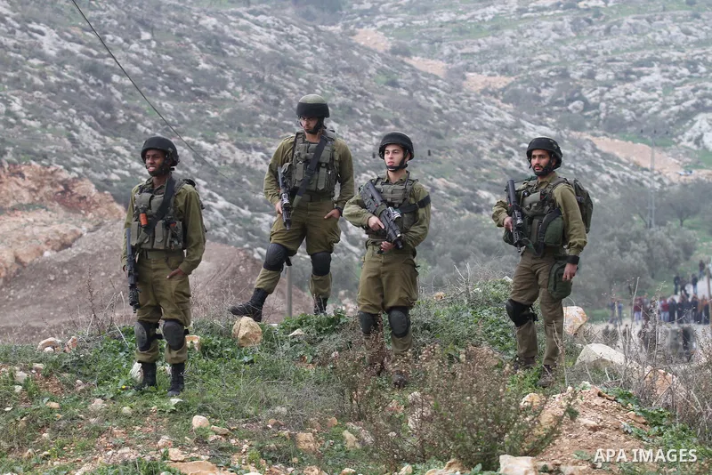 Israeli security forces monitor the site where a Palestinian man was shot dead following a reported stabbing attack in the village of Assira al-Shamaliya near the city of Nablus, in the occupied West Bank, on January 14,...