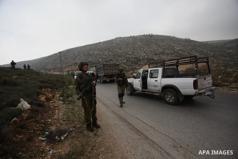 Israeli security forces monitor the site where a Palestinian man was shot dead following a reported stabbing attack in the village of Assira al-Shamaliya near the city of Nablus, in the occupied West Bank, on January 14,...
