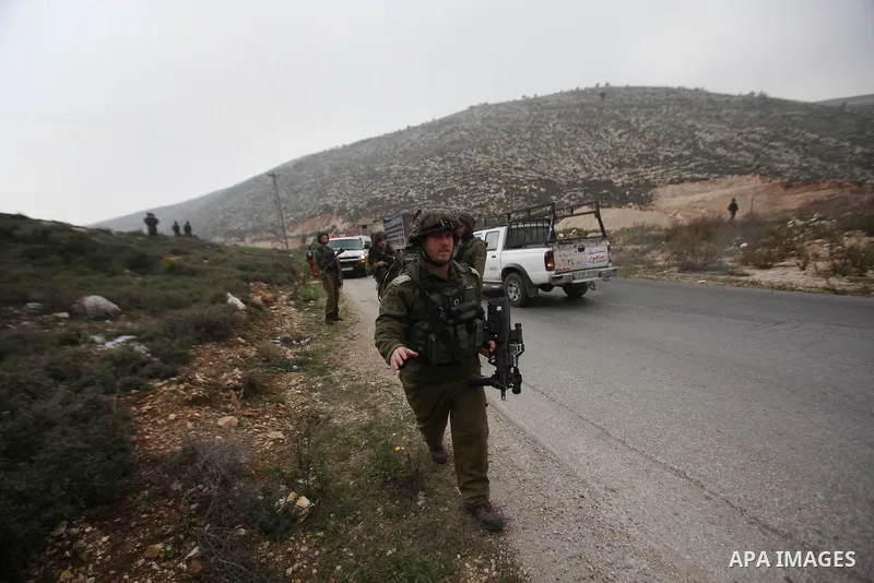Israeli security forces monitor the site where a Palestinian man was shot dead following a reported stabbing attack in the village of Assira al-Shamaliya near the city of Nablus, in the occupied West Bank, on January 14,...