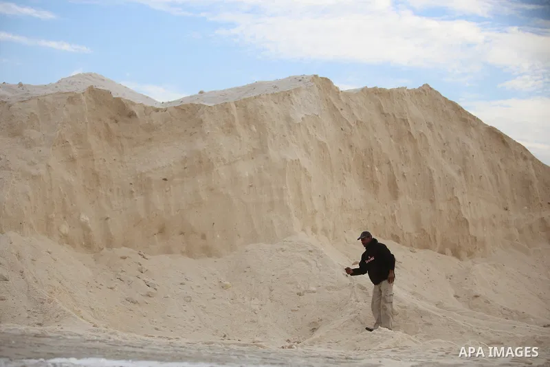 A Palestinian worker extracts salt from the Dead Sea, outside his factory in the West Bank city of Jericho on January 14, 2016. The Dead Sea also called the Salt Sea, is a salt lake with borders to Jordan in the east and...