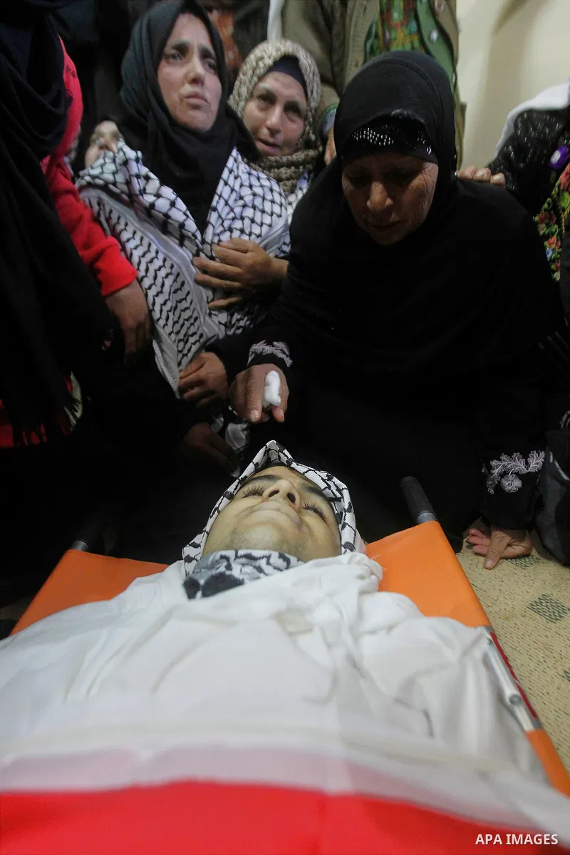 Relatives of the Palestinian Moayad al-Jabreen mourns over his body during his funeral in the West Bank village of Sair, east of Hebron, on January 15, 2016. The 20-year-old man was shot dead the previous day by Israeli...