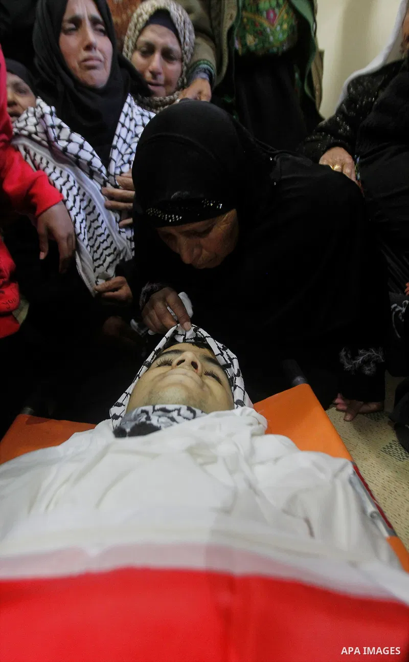 Relatives of the Palestinian Moayad al-Jabreen mourns over his body during his funeral in the West Bank village of Sair, east of Hebron, on January 15, 2016. The 20-year-old man was shot dead the previous day by Israeli...
