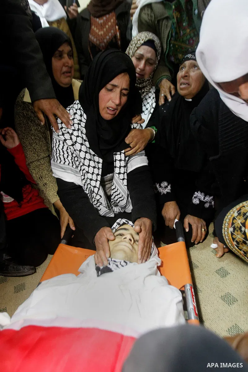 The mother of Moayad al-Jabreen mourns over his body during his funeral in the West Bank village of Sair, east of Hebron, on January 15, 2016. The 20-year-old man was shot dead the previous day by Israeli security forces...