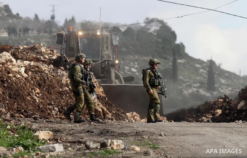 Israeli security forces take position during clashes with Palestinian protesters following a protest against the expropriation of Palestinian land by Israel in the West Bank village of Kafr Qaddum, near the northern city...