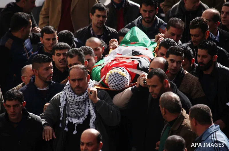 Palestinian mourners carry the body of Haytham Yassin during his funeral in the village of Assira al-Shamaliya near Nablus, in the Israeli-occupied West Bank, on January 15, 2016. The Palestinian man stabbed an Israeli s...