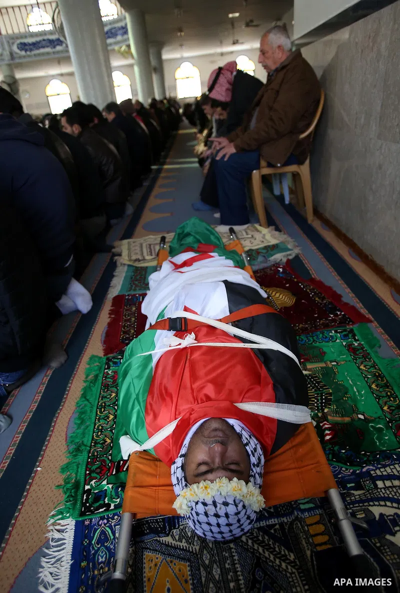 Palestinians pray at a mosque near the body of Haytham Yassin during his funeral in the village of Assira al-Shamaliya near Nablus, in the Israeli-occupied West Bank, on January 15, 2016. The Palestinian man stabbed an I...