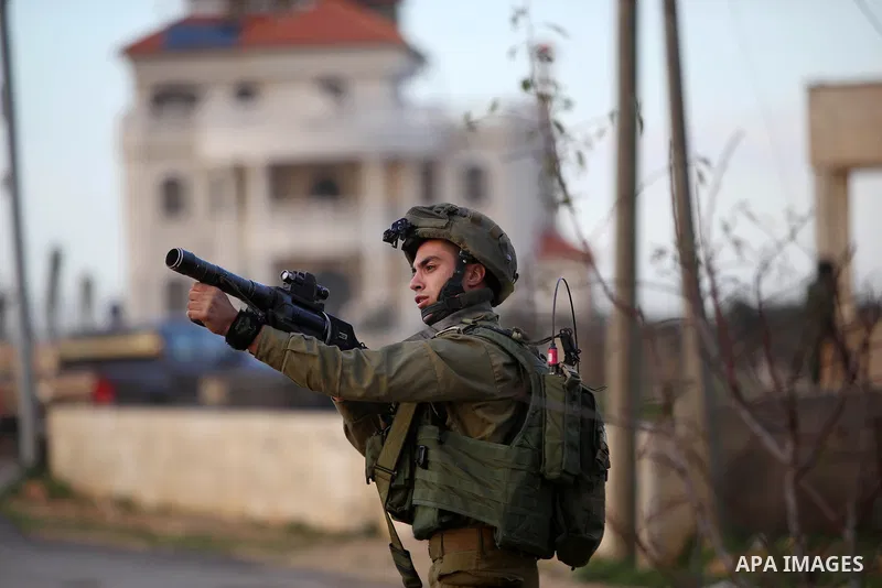 A member of Israeli security forces aims his weapon at Palestinian protesters during clashes in Jalazoun refugee camp near the West Bank city of Ramallah on Jan. 15, 2016. Photo by Shadi Hatem