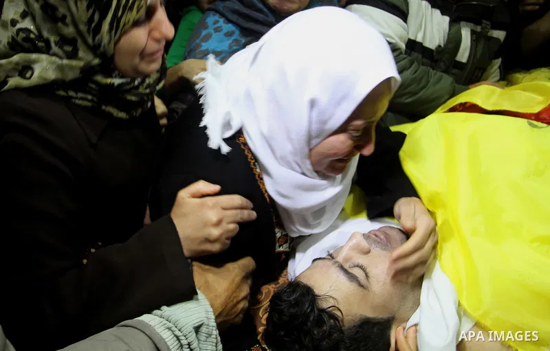 Relatives mourn during the funeral of Mohammed Qita in Khan Yunis in the southern Gaza Strip on January 16, 2016. Two Palestinians were shot dead by Israeli forces during protests along the border with Gaza on January 15...