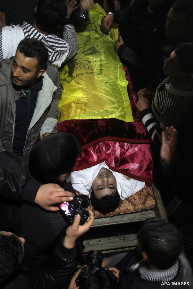 Palestinian carry the body of Mohammed Qita during his funeral, in Khan Yunis in the southern Gaza Strip on January 16, 2016. Two Palestinians were shot dead by Israeli forces during protests along the border with Gaza o...