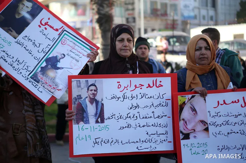 Palestinians from a human chain hold banners during a rally to show solidarity with the Palestine’s martyrs of the Intifada Jerusalem , in the West Bank city of Ramallah, on January 16, 2016. This has brought the number...