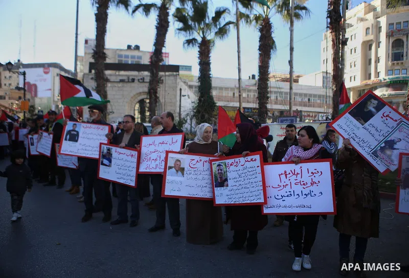 Palestinians from a human chain hold banners during a rally to show solidarity with the Palestine’s martyrs of the Intifada Jerusalem , in the West Bank city of Ramallah, on January 16, 2016. This has brought the number...
