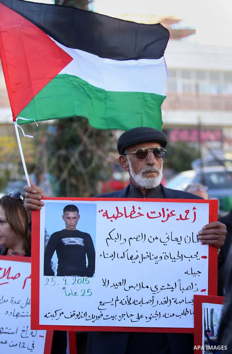 Palestinians from a human chain hold banners during a rally to show solidarity with the Palestine’s martyrs of the Intifada Jerusalem , in the West Bank city of Ramallah, on January 16, 2016. This has brought the number...