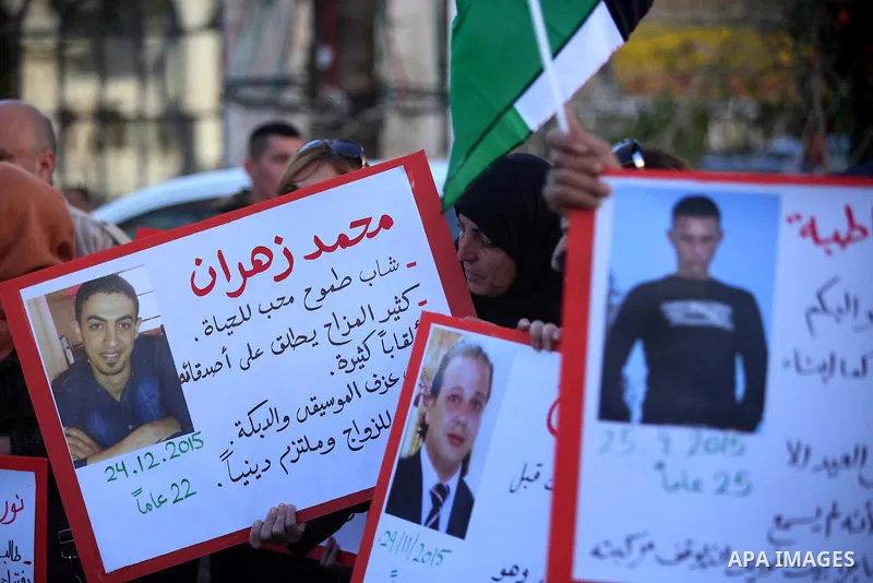 Palestinians from a human chain hold banners during a rally to show solidarity with the Palestine’s martyrs of the Intifada Jerusalem , in the West Bank city of Ramallah, on January 16, 2016. This has brought the number...