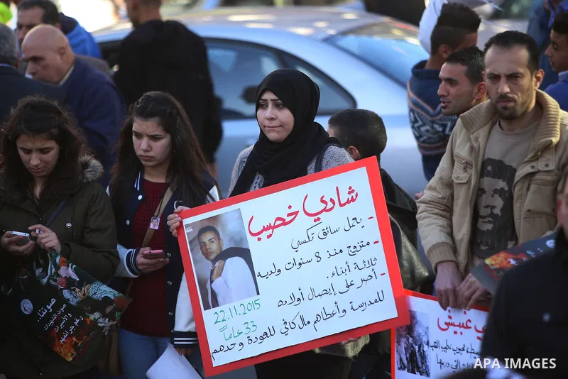 Palestinians from a human chain hold banners during a rally to show solidarity with the Palestine’s martyrs of the Intifada Jerusalem , in the West Bank city of Ramallah, on January 16, 2016. This has brought the number...