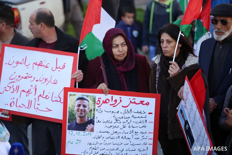 Palestinians from a human chain hold banners during a rally to show solidarity with the Palestine’s martyrs of the Intifada Jerusalem , in the West Bank city of Ramallah, on January 16, 2016. This has brought the number...