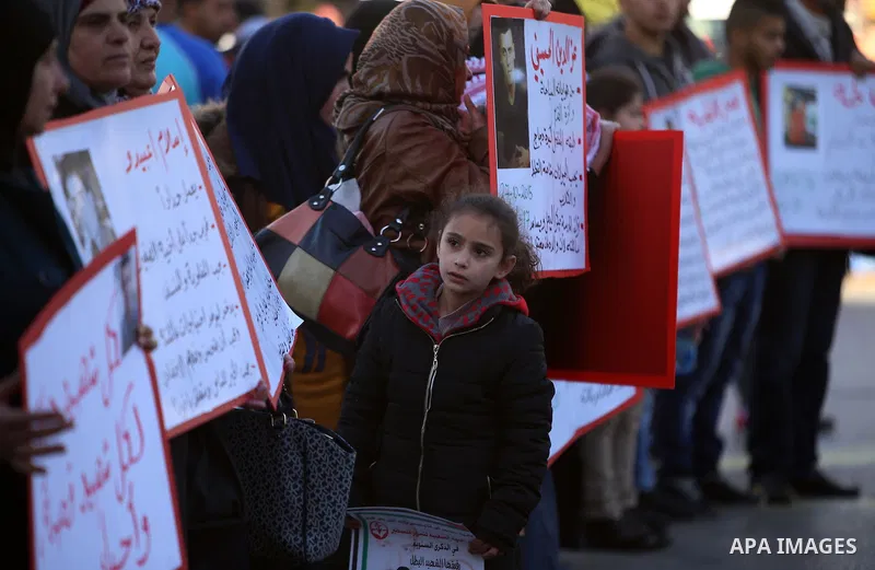 Palestinians from a human chain hold banners during a rally to show solidarity with the Palestine’s martyrs of the Intifada Jerusalem , in the West Bank city of Ramallah, on January 16, 2016. This has brought the number...