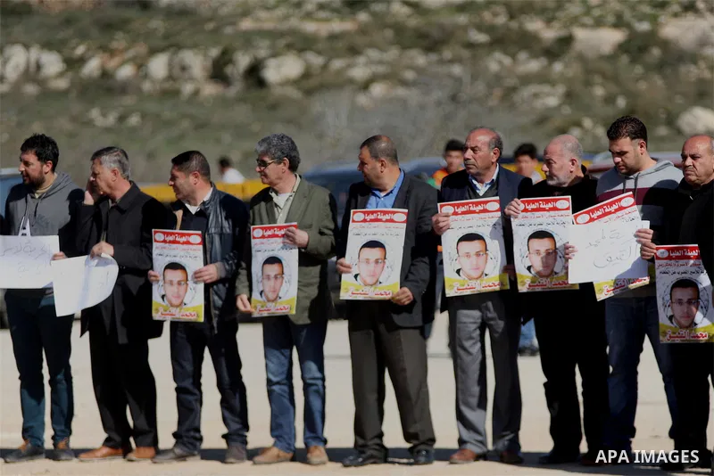 Palestinians take part in a demonstration demanding the release of Palestinian journalist Mohammed al-Qiq from Israeli jails, outside the compound of the Israeli Ofer Military prison, near the West Bank city of Ramallah,...