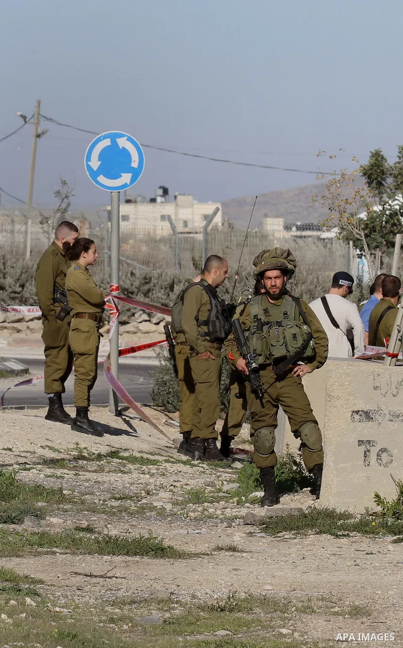 Israeli security forces gather near the scene where a Palestinian man was shot dead following a reported stabbing attack at the Hawara checkpoint, south of the West Bank city of Nablus, on Jan. 17, 2016. Israeli army Sun...