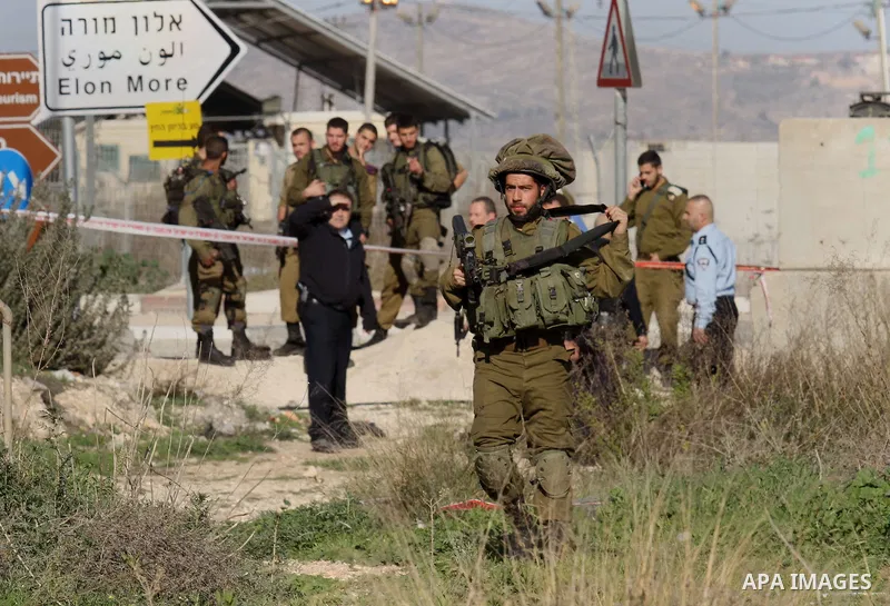 Israeli security forces gather near the scene where a Palestinian man was shot dead following a reported stabbing attack at the Hawara checkpoint, south of the West Bank city of Nablus, on Jan. 17, 2016. Israeli army Sun...