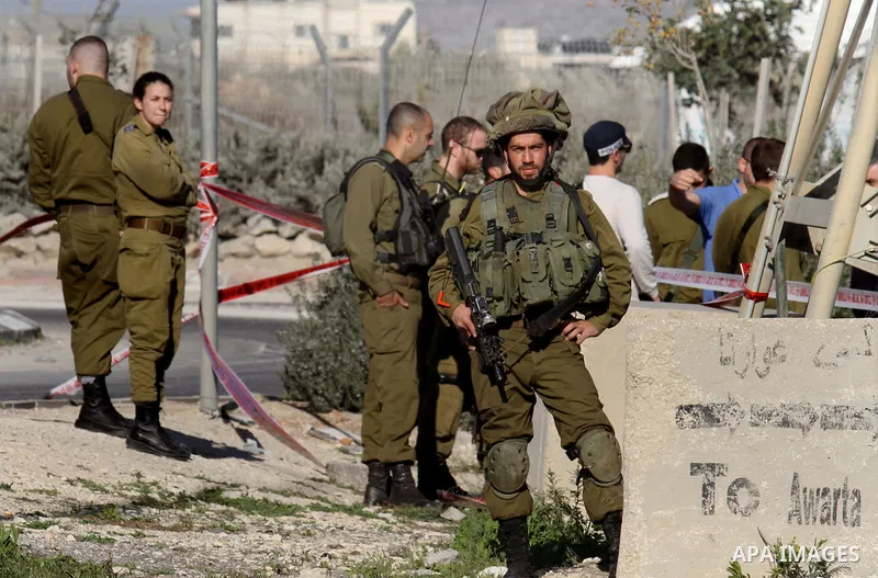 Israeli security forces gather near the scene where a Palestinian man was shot dead following a reported stabbing attack at the Hawara checkpoint, south of the West Bank city of Nablus, on Jan. 17, 2016. Israeli army Sun...