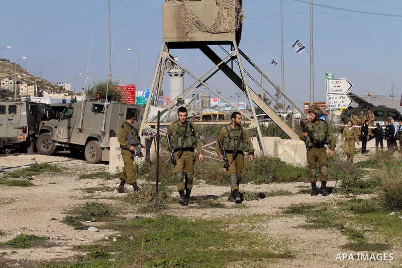 Israeli security forces gather near the scene where a Palestinian man was shot dead following a reported stabbing attack at the Hawara checkpoint, south of the West Bank city of Nablus, on Jan. 17, 2016. Israeli army Sun...