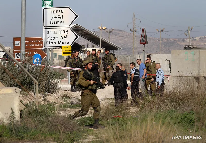 Israeli security forces gather near the scene where a Palestinian man was shot dead following a reported stabbing attack at the Hawara checkpoint, south of the West Bank city of Nablus, on Jan. 17, 2016. Israeli army Sun...