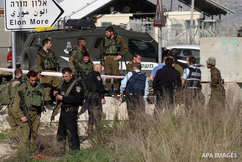 Israeli security forces gather near the scene where a Palestinian man was shot dead following a reported stabbing attack at the Hawara checkpoint, south of the West Bank city of Nablus, on Jan. 17, 2016. Israeli army Sun...