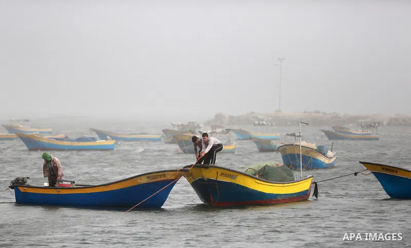 Fishing boats are seen at the Gaza port during a heavy storm on January 18, 2016. Photo by Yasser Qudih