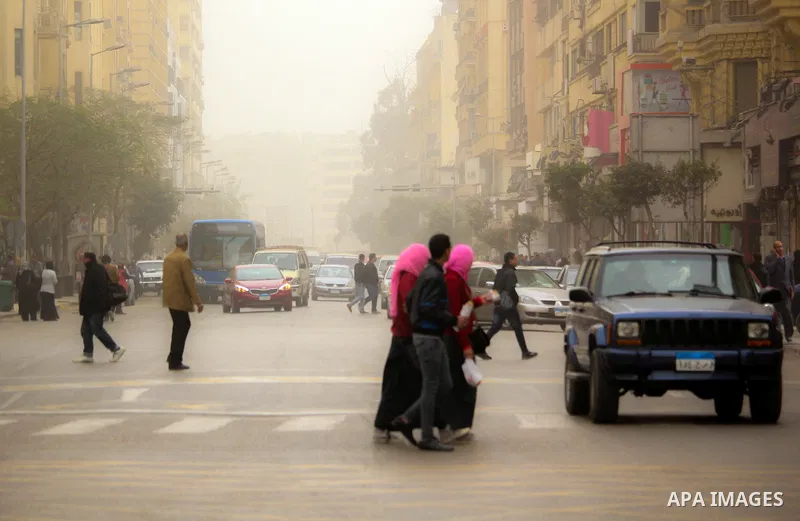 Egyptians walk at a street during sandstorm in Cairo, Egypt, on Jan. 18, 2016. Photo by Amr Sayed