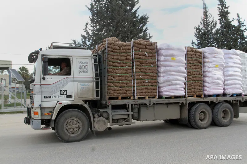Trucks loaded with goods enter the Gaza Strip from Israel through the Kerem Shalom crossing in Rafah in the southern Gaza Strip on Jan. 18, 2016. Photo by Abed Rahim Khatib
