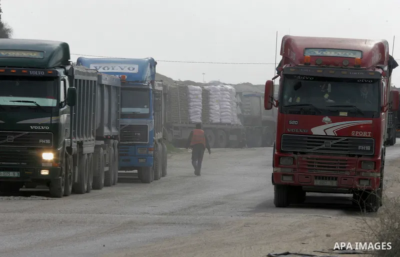 Trucks loaded with goods enter the Gaza Strip from Israel through the Kerem Shalom crossing in Rafah in the southern Gaza Strip on Jan. 18, 2016. Photo by Abed Rahim Khatib