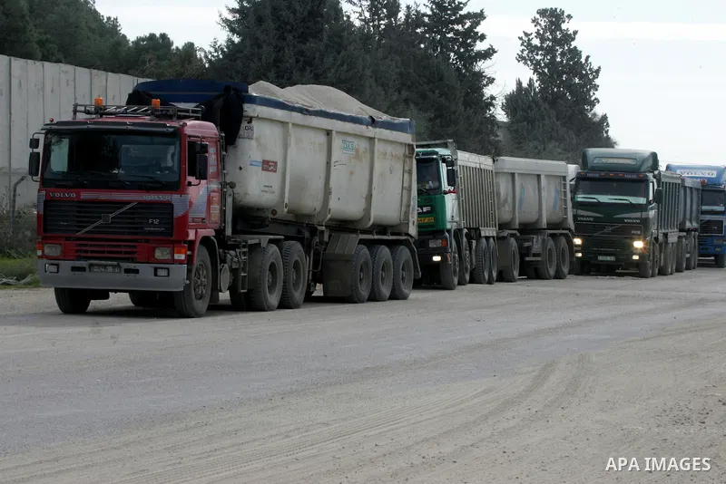Trucks loaded with goods enter the Gaza Strip from Israel through the Kerem Shalom crossing in Rafah in the southern Gaza Strip on Jan. 18, 2016. Photo by Abed Rahim Khatib
