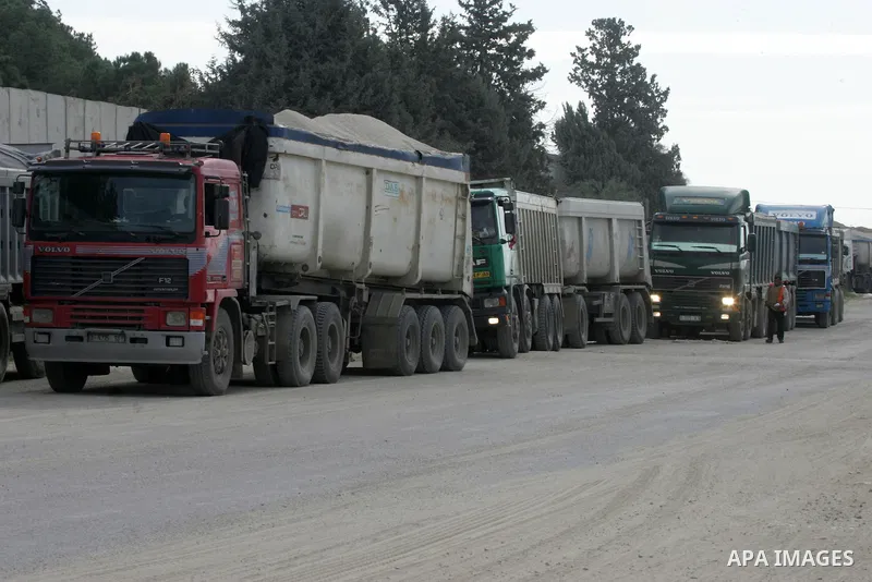 Trucks loaded with goods enter the Gaza Strip from Israel through the Kerem Shalom crossing in Rafah in the southern Gaza Strip on Jan. 18, 2016. Photo by Abed Rahim Khatib