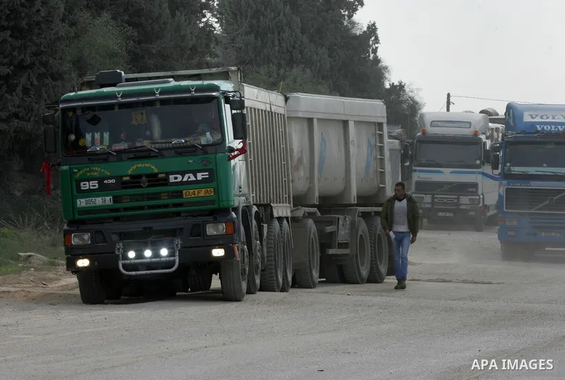 Trucks loaded with goods enter the Gaza Strip from Israel through the Kerem Shalom crossing in Rafah in the southern Gaza Strip on Jan. 18, 2016. Photo by Abed Rahim Khatib