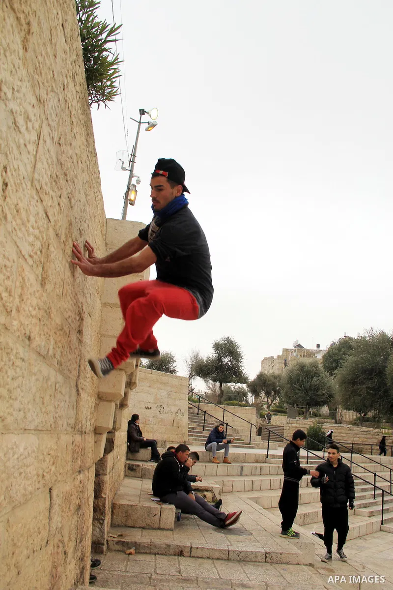 A Palestinian youth demonstrates his parkour skills in front of Damascus gate, in Jerusalem's old city on Jan. 19, 2016. Photo by Mahfouz Abu Turk