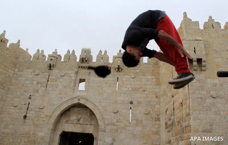 A Palestinian youth demonstrates his parkour skills in front of Damascus gate, in Jerusalem's old city on Jan. 19, 2016. Photo by Mahfouz Abu Turk