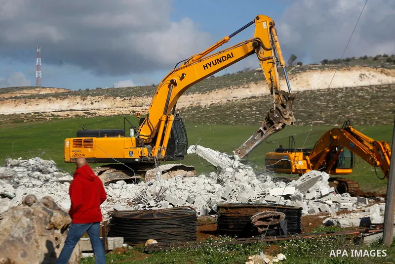 An Israeli bulldozer demolishes a Palestinian house under the order of the Israeli army, in the West Bank town of Dura, south of Hebron January 20, 2016. The owners of the house said they were informed by the Israeli arm...
