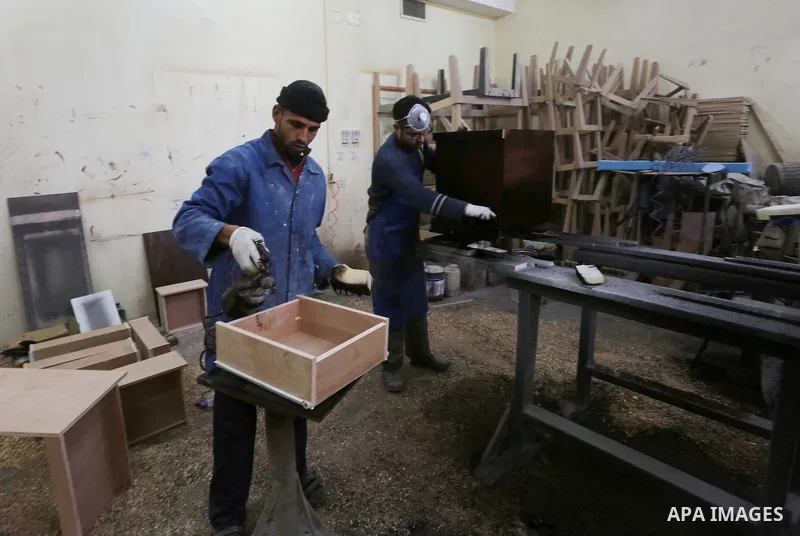Palestinians disabled work on wood to make furniture during participate in a project titled "Erada" funded by the Turkish President Ragab Ardogan at the Islamic university, in Gaza City, on January 20, 2016. Photo by Moh...