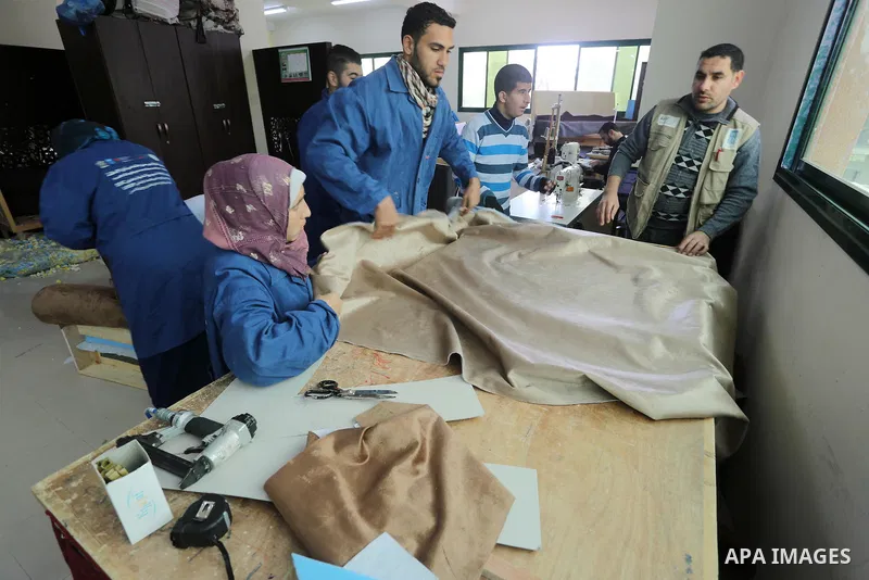 Palestinians disabled work on wood to make furniture during participate in a project titled "Erada" funded by the Turkish President Ragab Ardogan at the Islamic university, in Gaza City, on January 20, 2016. Photo by Moh...