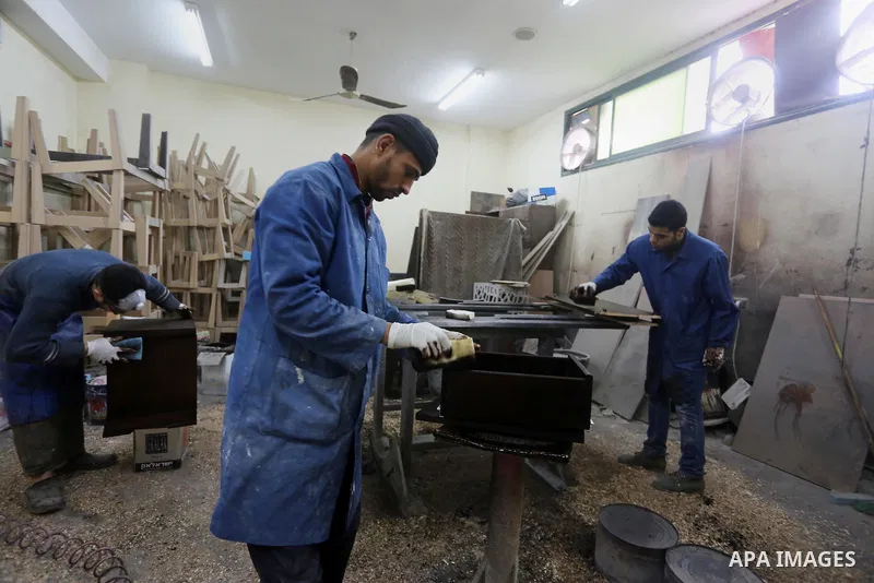 Palestinians disabled work on wood to make furniture during participate in a project titled "Erada" funded by the Turkish President Ragab Ardogan at the Islamic university, in Gaza City, on January 20, 2016. Photo by Moh...