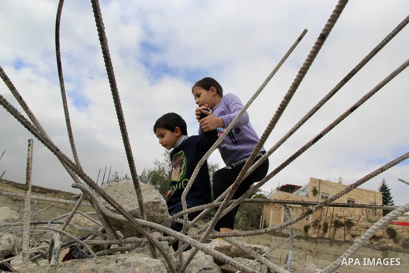 Palestinian children walk on the rubbles of thier family house that was demolished after Israeli authorities said it was built without a permit in Wadi Qaddum in the East Jerusalem neighborhood of Silwan on Jan. 20, 2016...