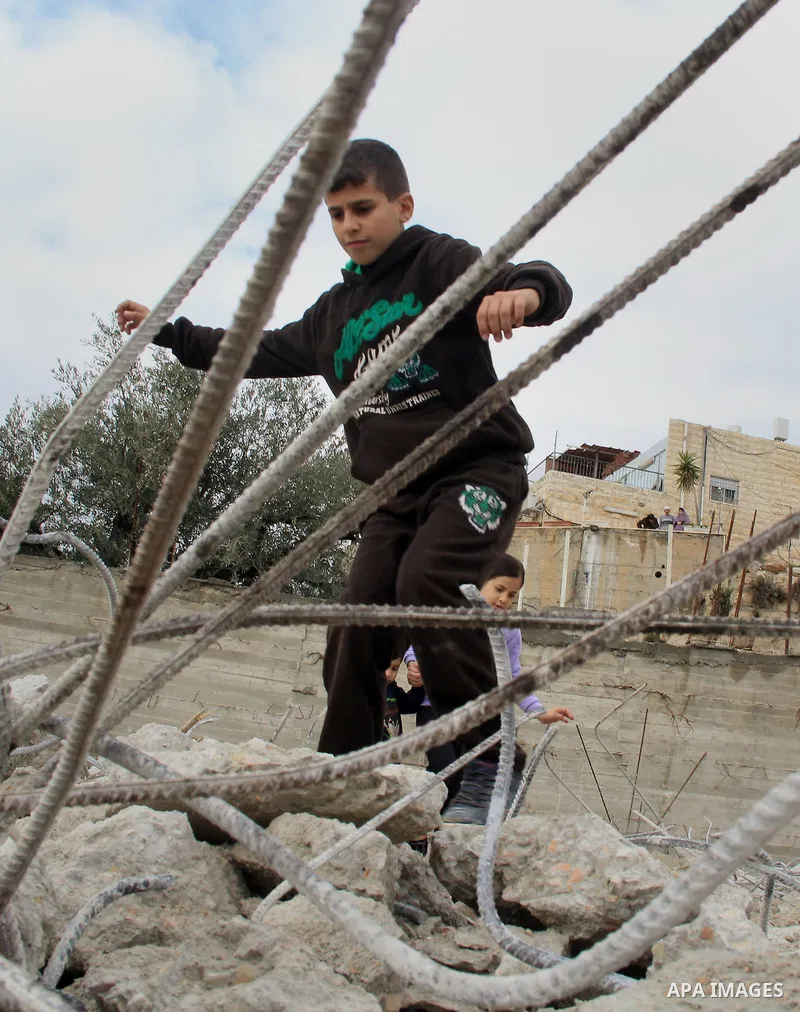 Palestinian children walk on the rubbles of thier family house that was demolished after Israeli authorities said it was built without a permit in Wadi Qaddum in the East Jerusalem neighborhood of Silwan on Jan. 20, 2016...