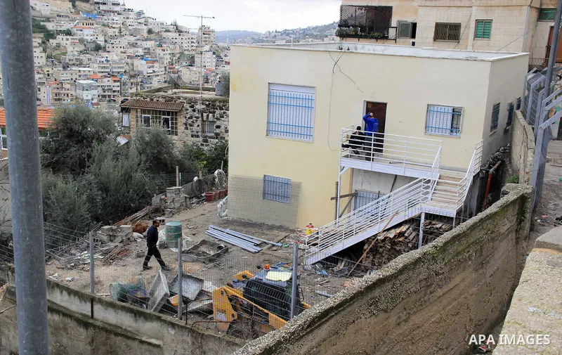 Israeli settlers sit on the balcony of house which the Palestinian Abu Tir family has for years that was taken over by Israeli settlers backed by police in the East Jerusalem neighbourhood of Silwan on Jan. 20, 2016. Sil...