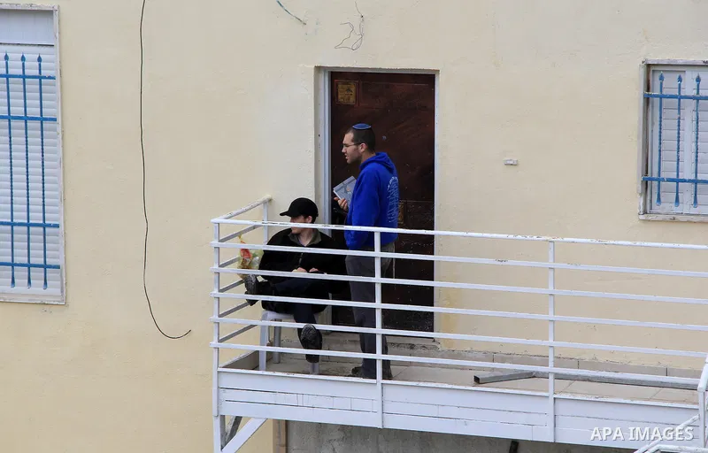 Israeli settlers sit on the balcony of house which the Palestinian Abu Tir family has for years that was taken over by Israeli settlers backed by police in the East Jerusalem neighbourhood of Silwan on Jan. 20, 2016. Sil...