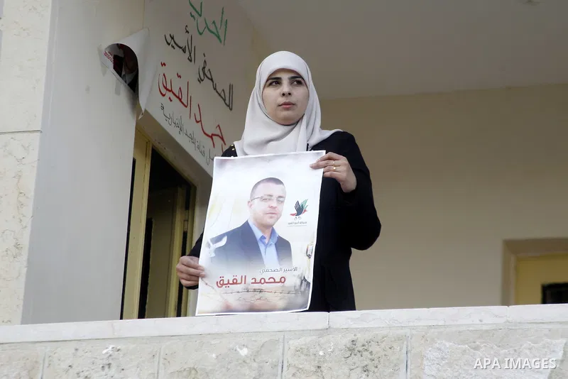 Fayha Shalash, the wife of Palestinian journalist Mohammed al-Qiq who is on hunger strike, holds his picture at her home in the West Bank village of Dura on January 20, 2016. Qiq, a 33-year-old reporter for Saudi TV chan...