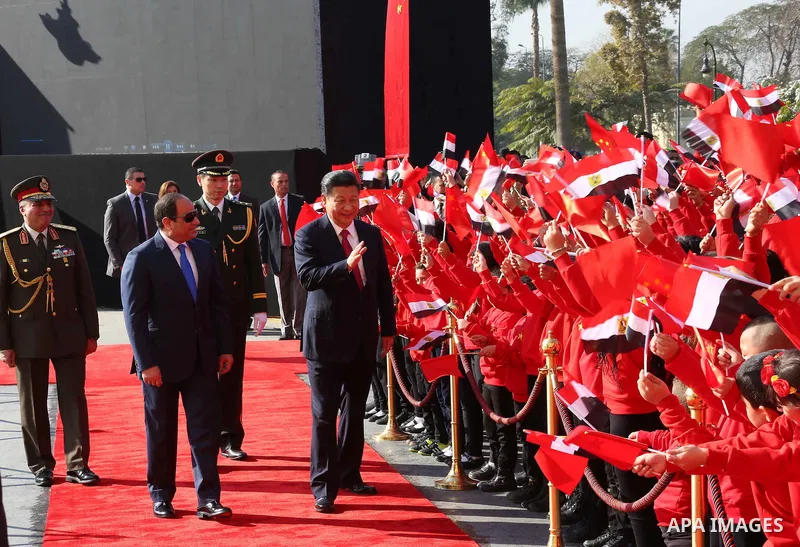 Children carrying Chinese flags cheer as Egyptian President Abdel Fattah al-Sisi (L) walks with Chinese President Xi Jinping (R) at the presidential palace during their meeting in Cairo, Egypt, January 21, 2016, in this...
