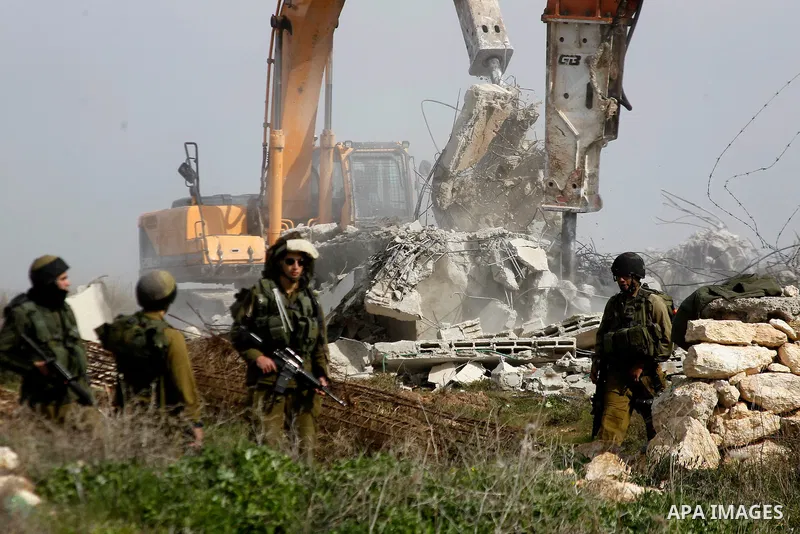 Israeli soldiers stand guard during the demolition of a Palestinian house at the order of the Israeli army in the West Bank village of Biet Ula, west of Hebron January 21, 2016. The owners of the house said they were inf...