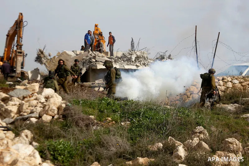 Israeli soldiers stand guard during the demolition of a Palestinian house at the order of the Israeli army in the West Bank village of Biet Ula, west of Hebron January 21, 2016. The owners of the house said they were inf...