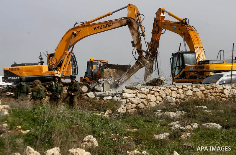 Israeli soldiers stand guard during the demolition of a Palestinian house at the order of the Israeli army in the West Bank village of Biet Ula, west of Hebron January 21, 2016. The owners of the house said they were inf...