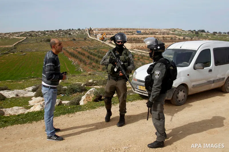 A Palestinian man argues with Israeli soldiers during the demolition of a Palestinian house at the order of the Israeli army as he tries to stop the demolition in the West Bank village of Biet Ula, west of Hebron January...